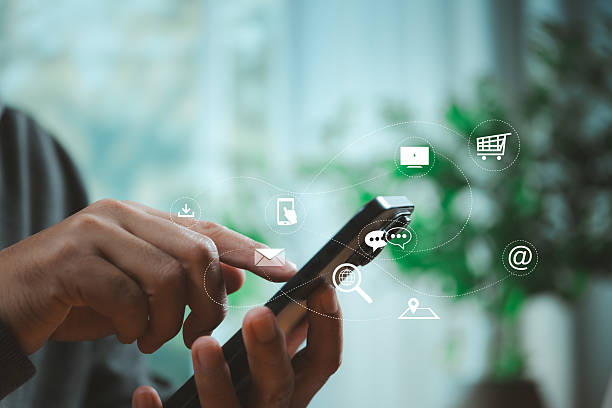 istock Person using smartphone with floating digital app icons representing cloud services, messaging, shopping, and online business technology in modern lifestyle. 2224844423