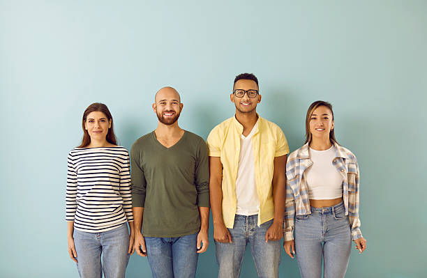 istock Multiracial group of happy, smiling young people standing against blue studio background 2224849016