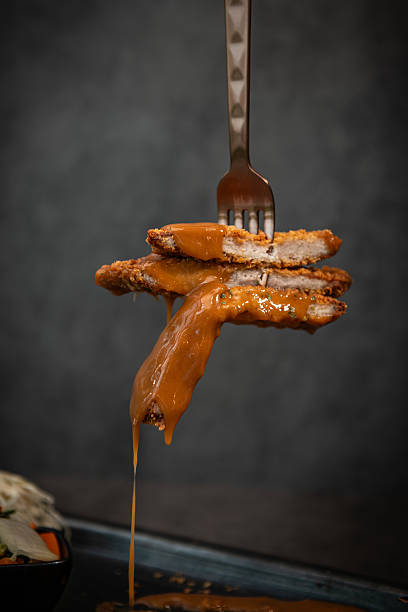 istock Chicken Cutlets with Sauce Drizzling, Placed on a Fork 2224849364