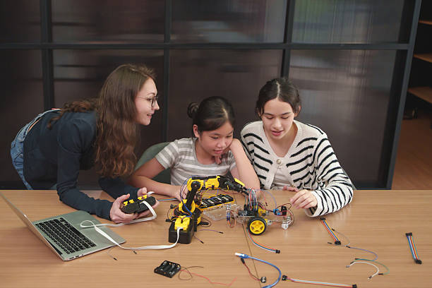 istock Young Teacher and student girls learning robotics and coding together in a modern classroom. 2224849385