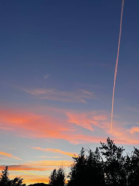 istock Jet vapor trail lit up by the sun at sunset 2224851312