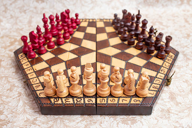 istock Three player chess board with black, white and red color pieces, on hexagonal shaped wooden board 2224852540