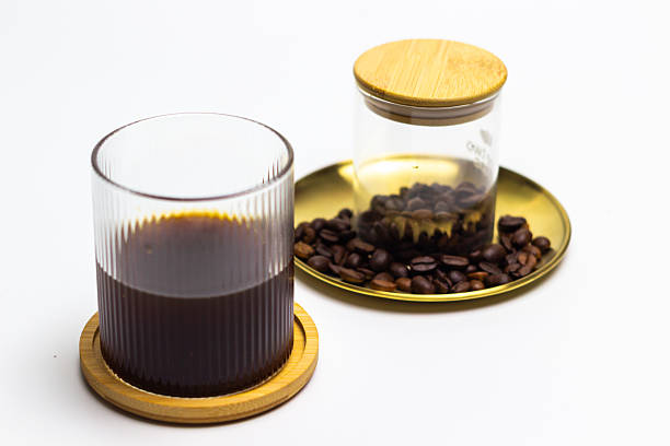 istock Elegant coffee presentation with glass and beans on a clean white background showcasing freshness 2224860257