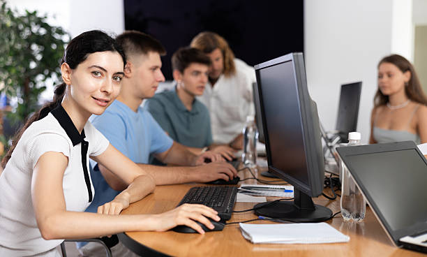 istock Among  students of  computer academy programmers, young girl is sitting and smiling, looking away 2224863197