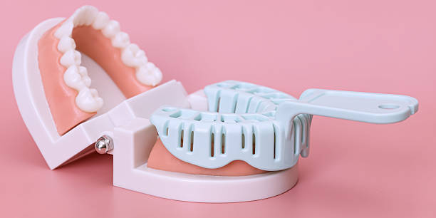 istock Dental impression tray and teeth model on pink 2224864045