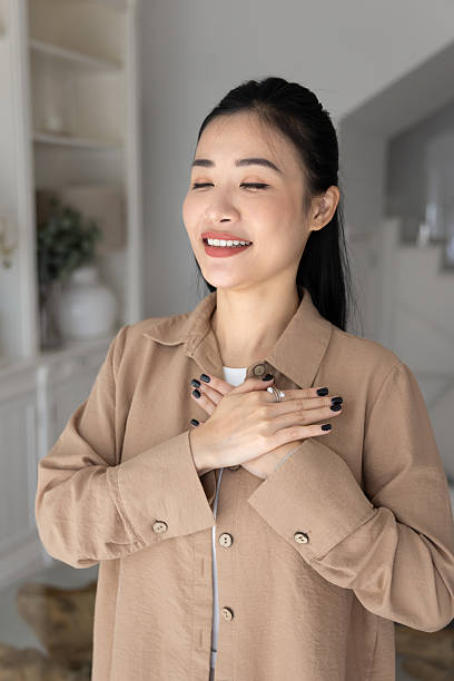 istock Woman put her folded palms on chest with eyes closed 2224864408