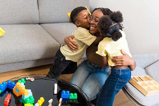 istock Two children hugging their mother at home 2224866826