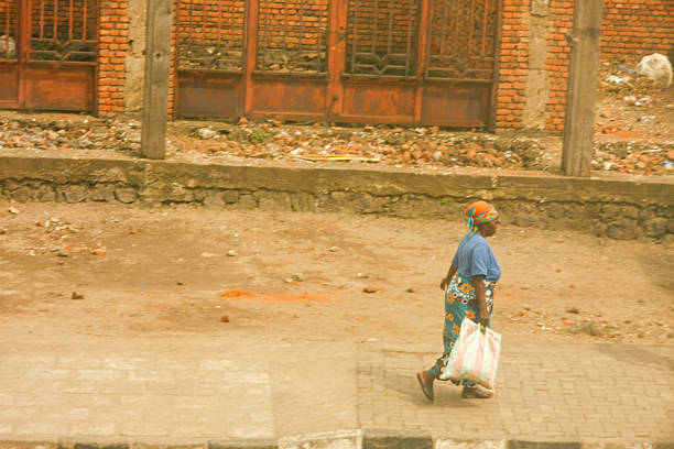 This photograph portrays a woman engaged in her daily routine in Rubavu, Rwanda. Her traditional attire and the act of carrying a bag provide an authentic glimpse into the rhythm of life for residents in the city.