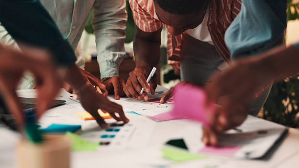 istock People, hands or meeting with documents for planning, schedule or brainstorming together at office. Closeup, group or team working with paperwork or sticky note for sharing ideas on creative strategy 2224867443