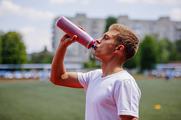 istock Athlete Runner Drinking Water for Hydration after Training on Outdoor Stadium Track 2224867936