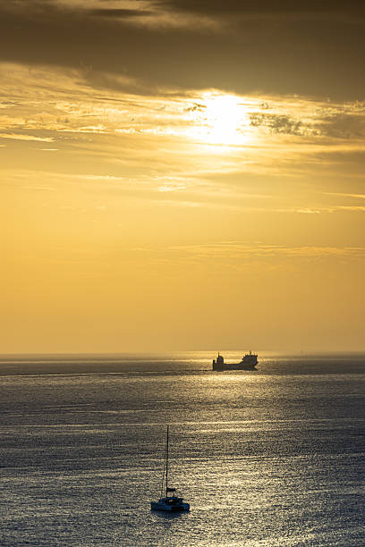 Spain, Fuerteventura, Morro Jable, November 21, 2024 - The silhouette of ships on the sea at sunset