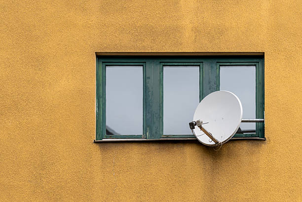 Germany, Berlin, Central Berlin, July 11, 2025 - A satellite dish on a window of a residential building