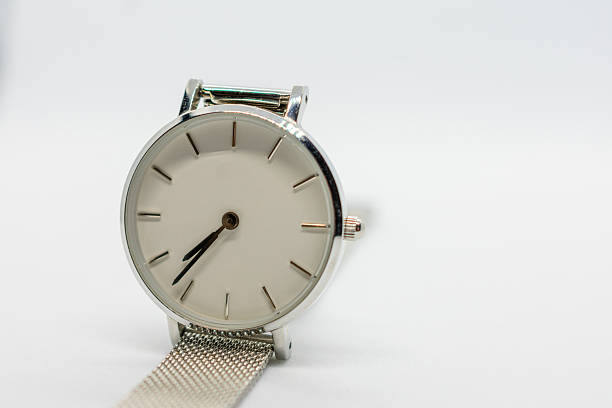 istock Silver watch with a white face sits on a white background. The watch is simple and elegant, with a clean design that emphasizes its functionality. The watch face is easy to read. 2224871616