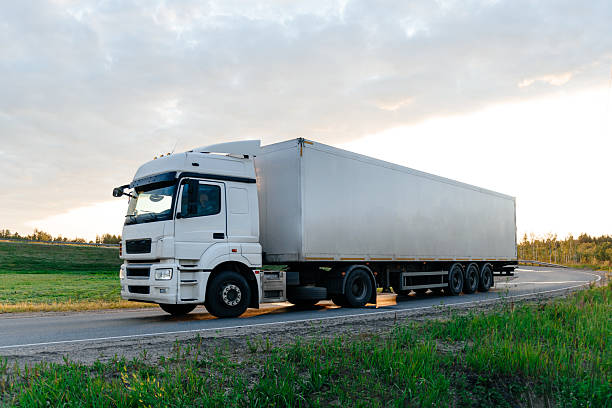 istock truck drives along road at sunset 2224874293