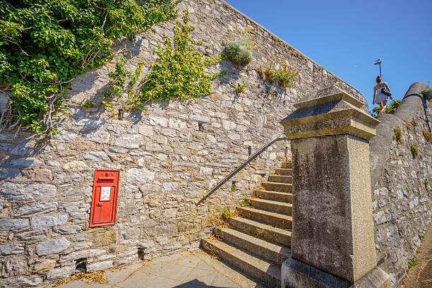 Plymouth, UK. 10 July 2025. Post Box and  woman at the top of steps up coast in Plymouth