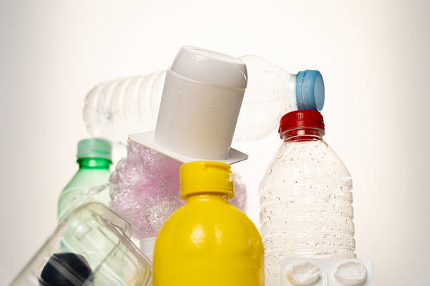 Close up photo of woman hands holding and recycling plastic against green background.