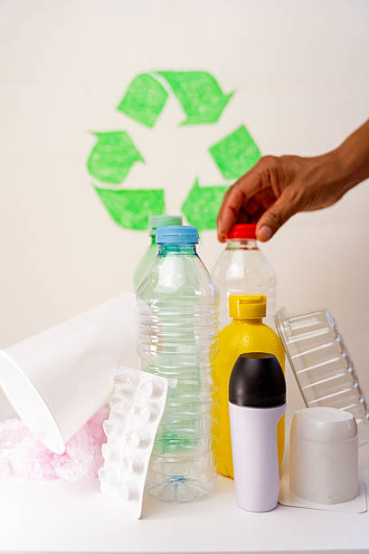istock Throwing plastic bottle into recycling bin, green background highlighting environmental responsibility and sustainable waste management 2224877638