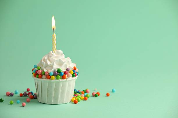 istock Birthday cupcake with burning candle on turquoise background. Space for text 2224877817