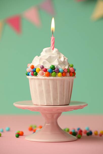 istock Birthday cupcake with burning candle on pink table 2224877840