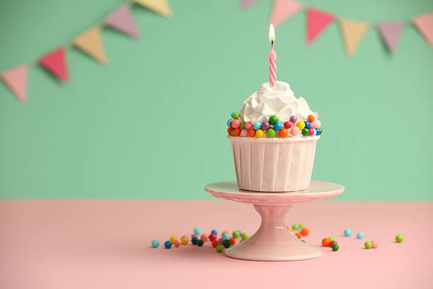 istock Birthday cupcake with burning candle on pink table. Space for text 2224877863