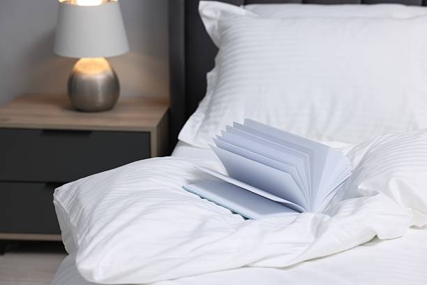 istock Open book on bed with clean linens indoors 2224877958