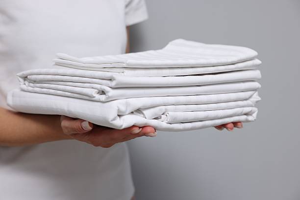 istock Woman with clean bed linens on grey background, closeup 2224877966
