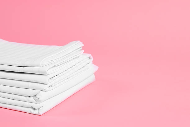 istock Stack of clean bed linens on pink background, space for text 2224878014