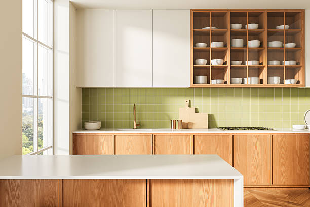 istock Modern kitchen interior with wooden cabinets, green tile backsplash, and minimalist white countertops in bright natural light. 3D Rendering. 3D Rendering 2224878223