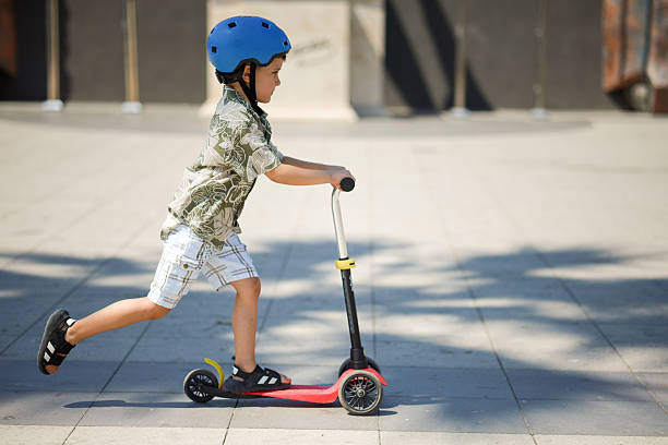 istock Little boy riding kick scooter 2224880541