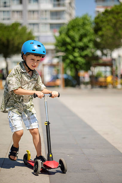 istock Little boy riding kick scooter 2224880571