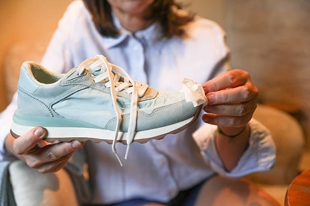istock Wiping Dirt Off White Sneakers Indoors 2224887783