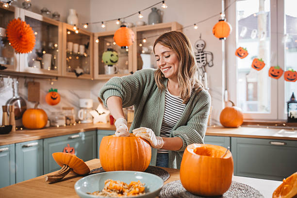 istock Woman carving pumpkin for Halloween 2224888411