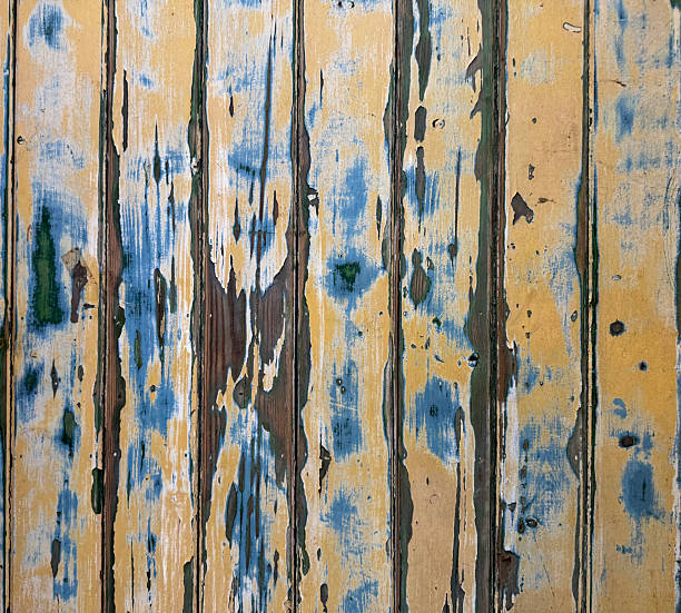 Old weathered blue and yellow paint on a wooden door