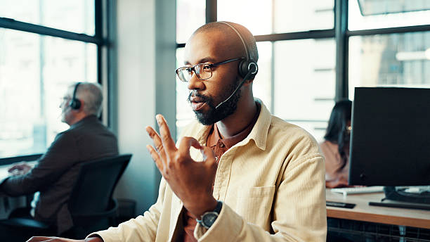 istock Customer service, perfect or man with headset at call center for support, loan advice or FAQ. Good gesture, sales agent and communication on computer for inbound query, online assistance or insurance 2224890610