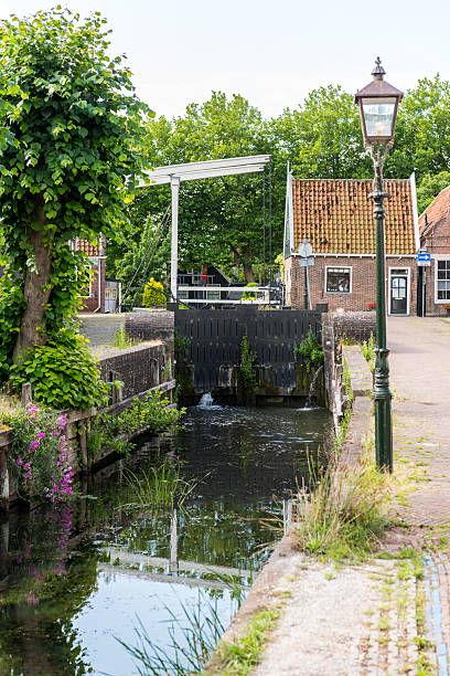 Very old sluice in the IJe, a small stream in the old town of Edam along the IJsselmeer in The Netherlands. Edam is famous for its cheese.