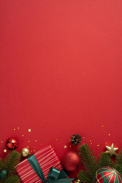 istock Red background with Christmas presents, ornaments, pine branches, and festive decorations. Perfect for holiday-themed designs, seasonal greetings, and promotional materials emphasizing the joy and color of the Christmas season. 2224893336