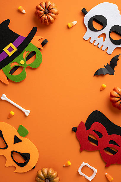 istock Halloween vertical decorations featuring vibrant masks and accessories against an orange background, conveying festivity and fun 2224893366