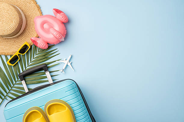 istock Bright summer-themed scattered travel items, including a suitcase, palm leaf, and accessories 2224893422