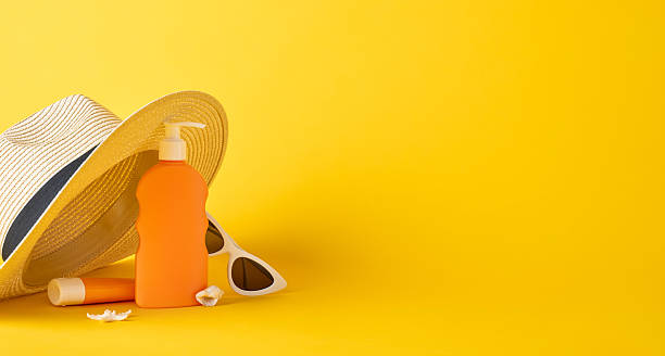 istock Bright composition featuring a sun hat, sunscreen, and sunglasses on a vibrant yellow surface 2224893426