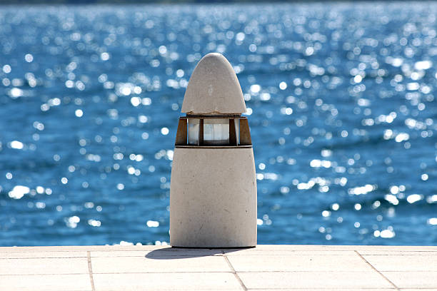 A scenic view of a wooden pier extending into the turquoise Adriatic Sea, with moored boats and a charming Croatian coastal village in the background. The bright summer sky, traditional architecture, and serene waterfront create a peaceful and inviting Mediterranean atmosphere.