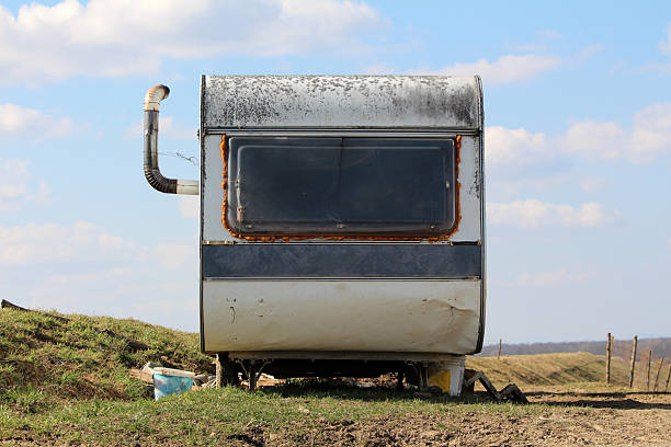 istock Derelict caravan with rusted window and chimney on grassy field 2224894981