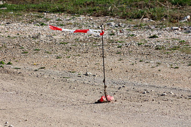 istock Tattered red and white warning tape on rocky construction ground 2224896286