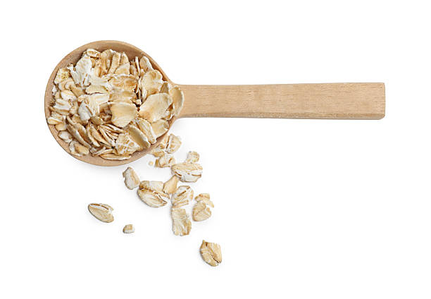 istock Oat flakes in spoon isolated on white, top view 2224897630