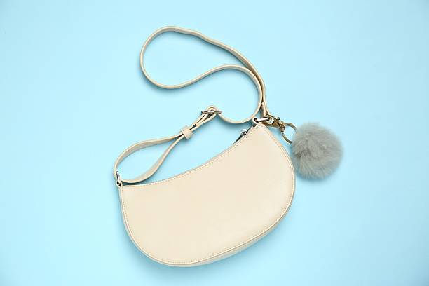 istock Bag with grey faux fur keychain on light blue background, top view 2224897869
