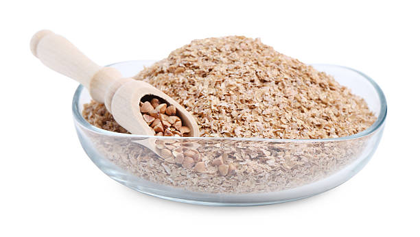 istock Buckwheat bran in glass bowl and grains isolated on white 2224898144