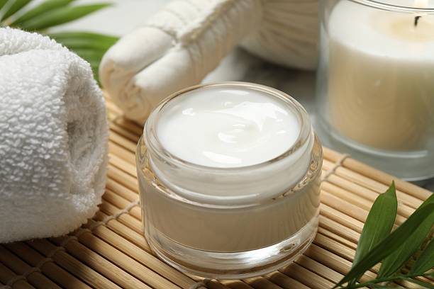 istock Spa composition with different cosmetic products, burning candle and leaves on white marble table, closeup 2224898614