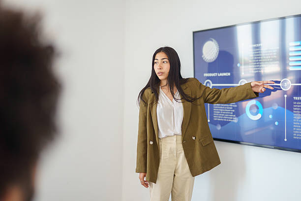istock Young Hispanic Businesswoman Presenting Data in Modern Office Setting 2224907479