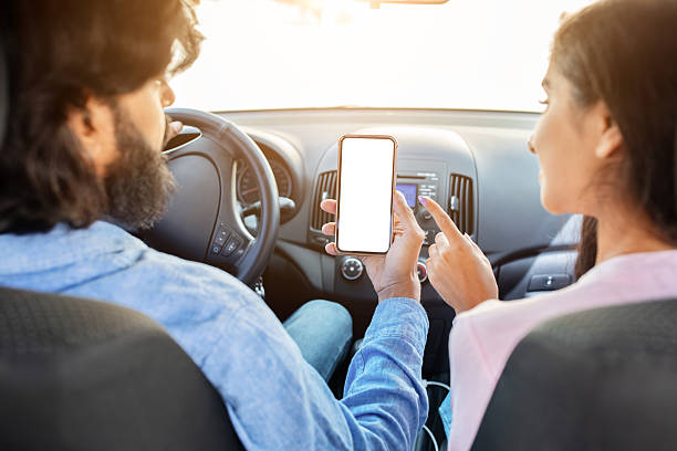 istock Indian couple using smartphone with blank white screen in car, discussing app 2224908387
