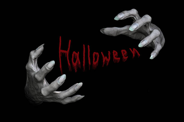 Bony pale male monsters hands with sharp nails and lettering Halloween between them, isolated on black. Symbol, holiday, witchcraft, evil, demon, spell and horror concept.