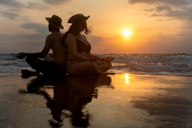 istock Couple meditating on beach at sunset, finding inner peace and harmony 2224912582